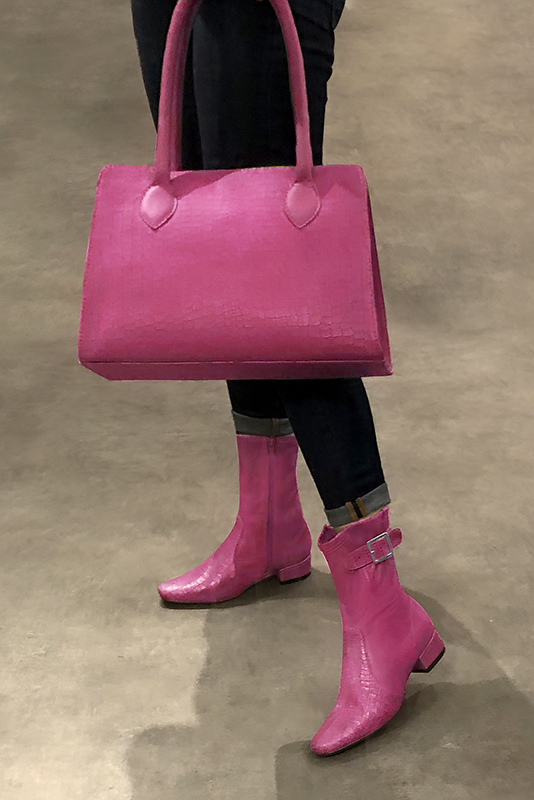 Fuschia pink women's ankle boots with buckles on the sides. Round toe. Low block heels. Worn view - Florence KOOIJMAN